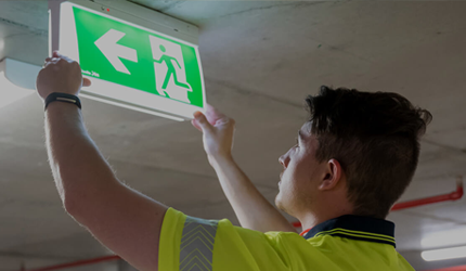 Worker installs passive fire protection to limit fire spread and meet compliance requirements during fire safety audit WA