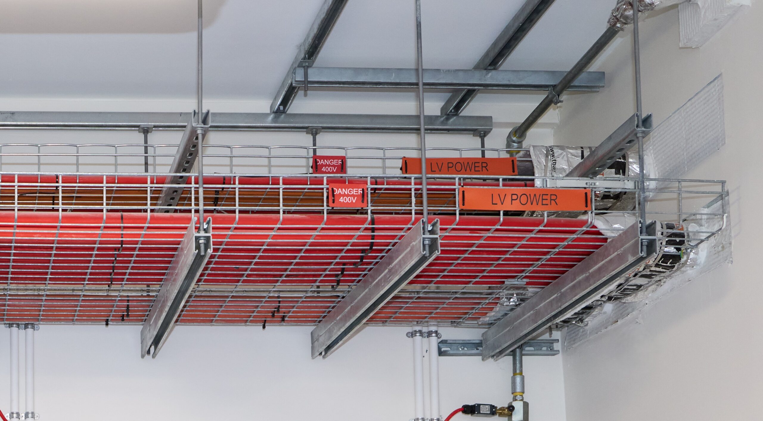 A metal rack displaying red and white wires, associated with Fire Protection Services WA