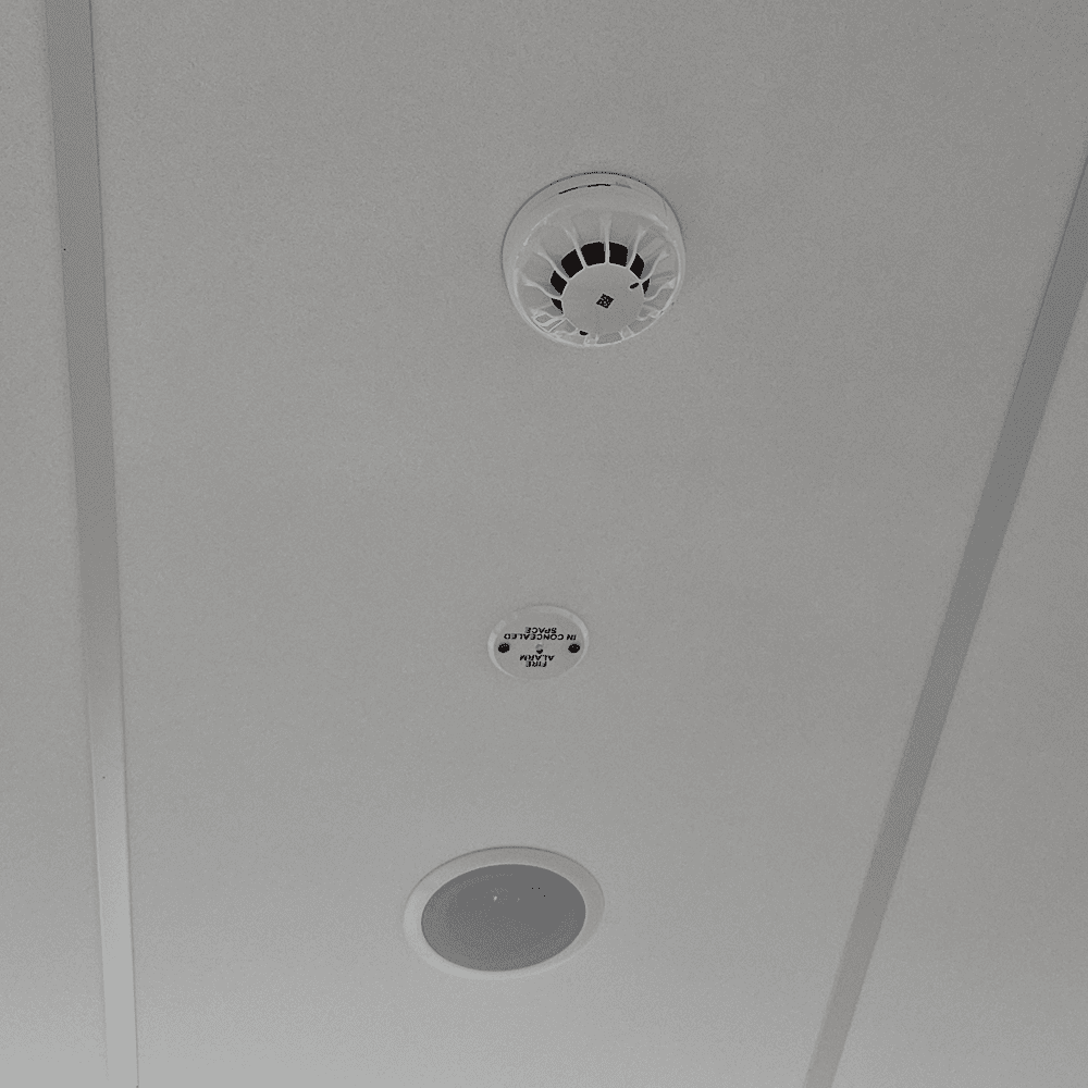 fire safety compliance WA - A white fire alarm placed on the ceiling